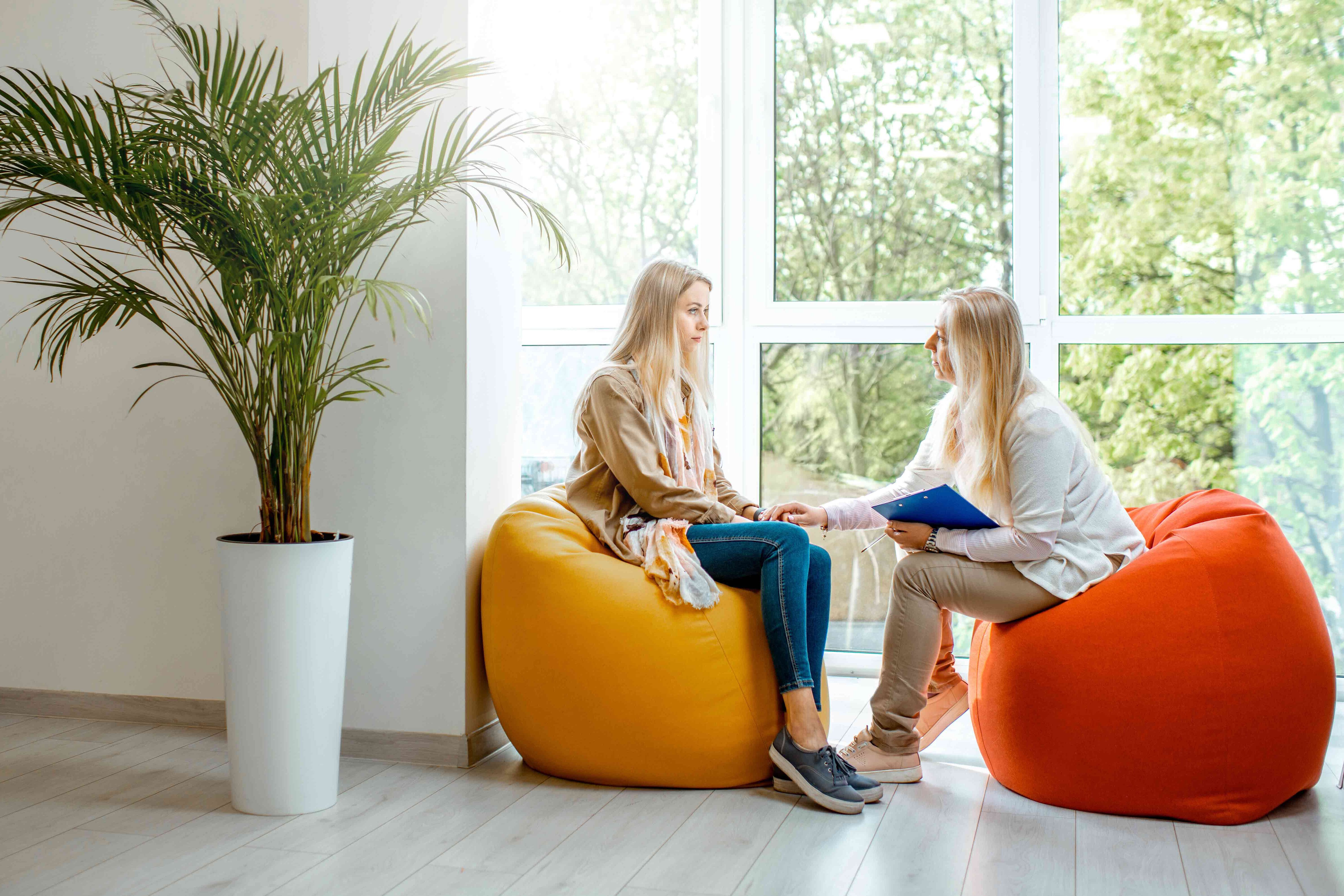 Eine junge Frau berät eine andere Frau.