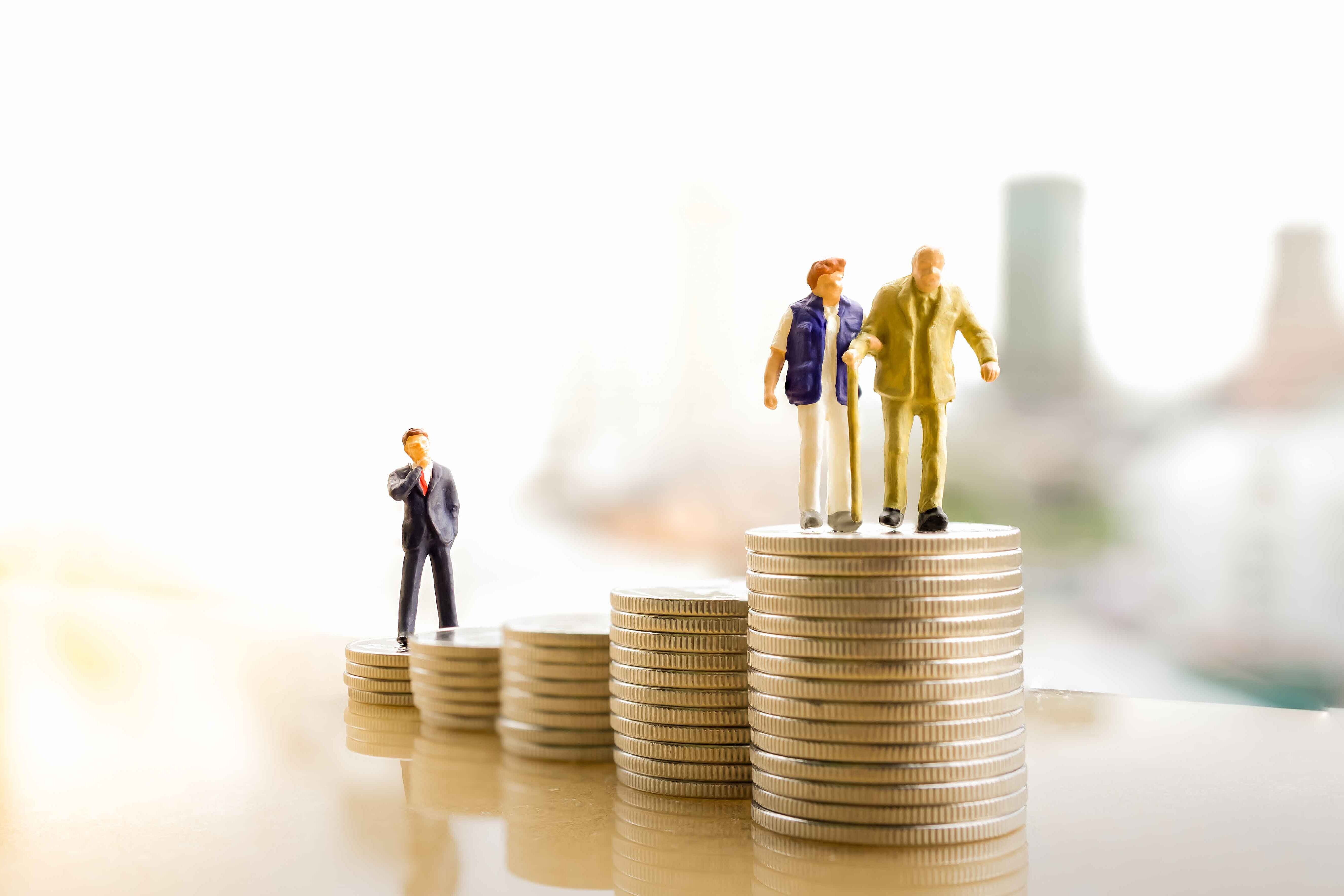 Zwei ältere Personen stehen auf Geldmünzen.