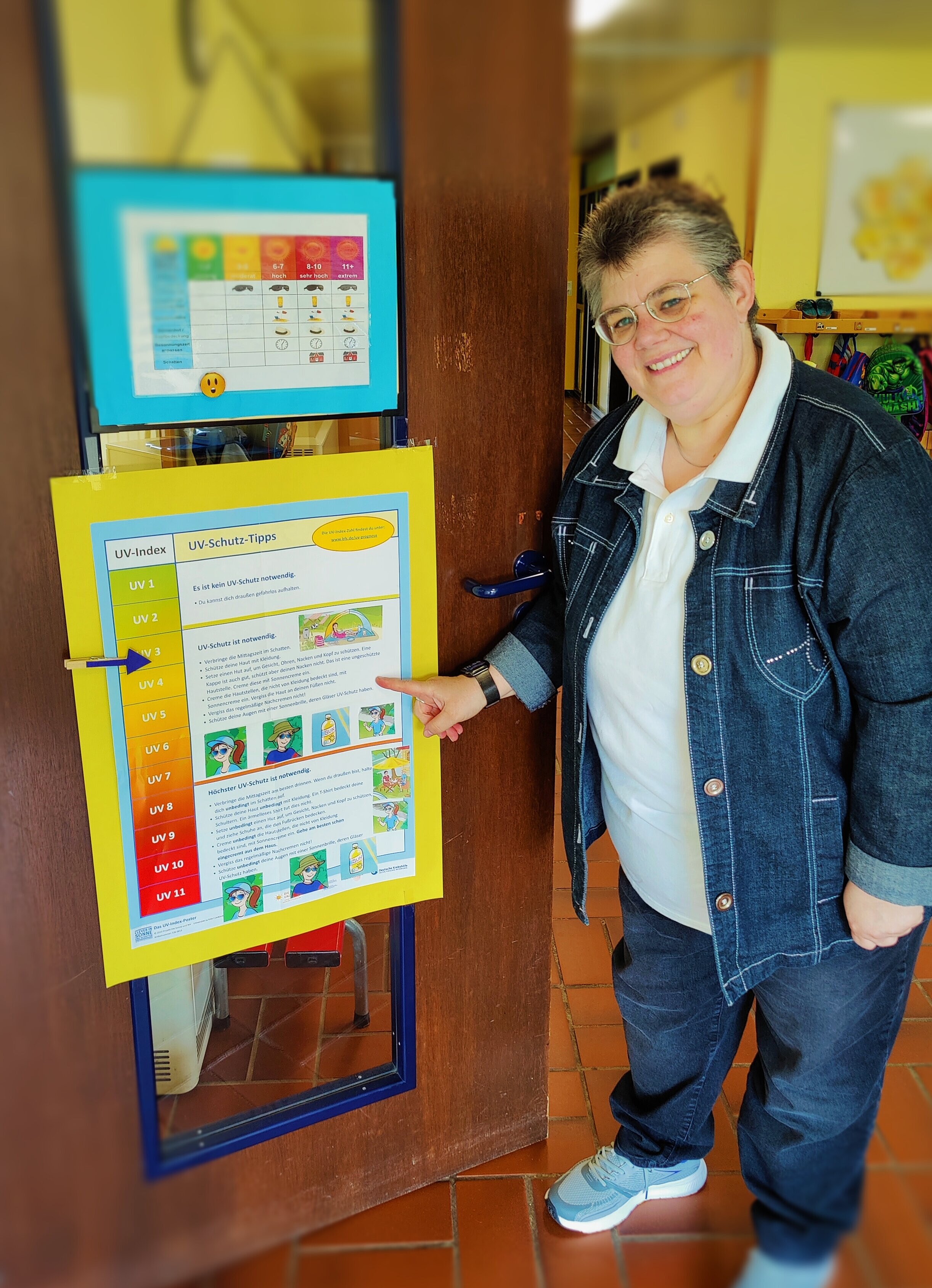 Kitaleitung Frau Koch erklärt die Tipps eines Sonnenschutz-Plakates